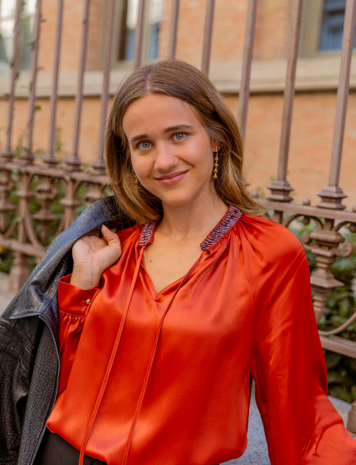 Blusa satinada roja con lazada en el escote: fotografía 1